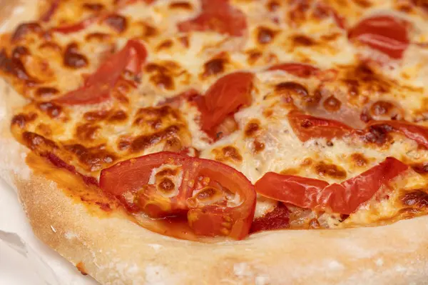 Lezzetli ev yapımı domuz pastırması, erimiş peynir ve taze domatesli bir pizza. Yemek siteleri ve yemek reklamları için ideal..