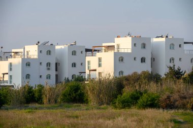 Beyaz mimari yapılar, batan güneşin sıcacık parıltısı altında yemyeşil ile çok güzel tezat oluşturuyor..