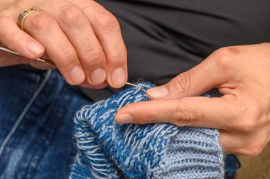 Renkli çoraplar ören bir kadın. Güzel bir deseni var. Doğal ışık altında..