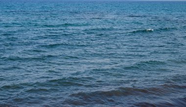 Huzurlu okyanus dalgaları sessizce dalgalanır, huzurlu bir kıyı öğleden sonranın huzurlu özünü yakalar..