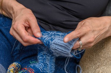 El yapımı örgü ören kadın çorabı.