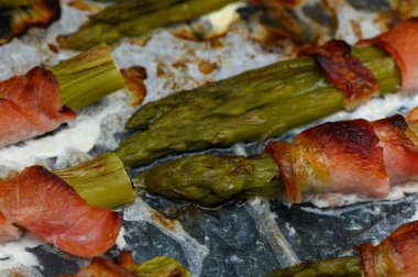 Lezzetli kuşkonmaz mızrakları çıtır çıtır pastırmaya sarılır. Gün batımı toplantılarında ızgarada cızırdar. Aroma havayı dolduruyor, paylaşmak için sıcak bir atmosfer yaratıyor..