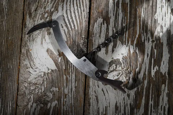 Güneş ışığı, kırsal ahşap üzerinde uzanan ve sıcaklık ve yaratıcılık hissi uyandıran el yapımı bir tirbuşonu ön plana çıkarıyor..