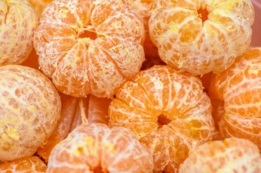 Parlak mandalina portakalları bir araya toplanmış, canlı derilerini sergiliyorlar ve güneş ışığı altında tatlılığa davet ediyorlar..