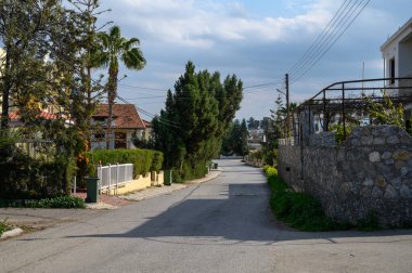 Bulutlu gökyüzünün altında yemyeşil ve büyüleyici evlerde sallanan sakin yol keşfi davet ediyor..