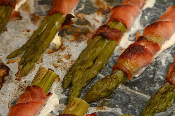 Kızarmış pastırmaya sarılı taze kuşkonmaz fırından çıkar, akşam yemeğinde lezzetli bir aperatif için mükemmeldir..