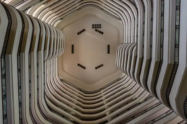 Bu çağdaş atriyumdaki çarpıcı kıvrımları ve simetriyi gözler önüne seriyor, dikkat çekici mimari tasarım seriyor..