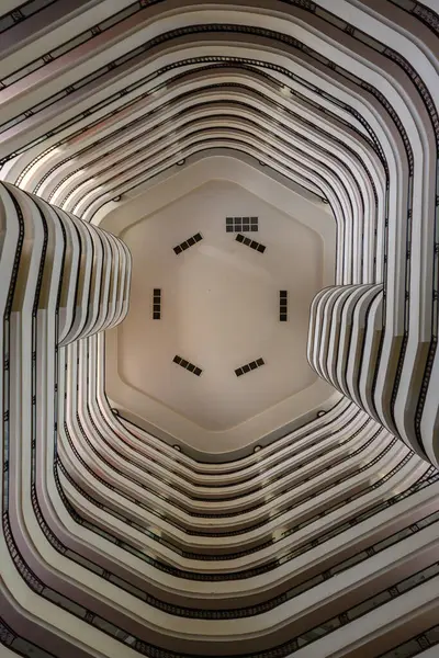 Büyüleyici aşağı doğru bakış açısı, çok katlı bir yapının zarif çizgilerini ve eğrilerini gözler önüne serer..