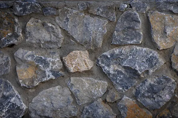 Yakından bakınca, doğal taşların karmaşık düzenini ortaya koyuyor, çeşitli doku ve renkler sergiliyor..