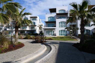 Parlak mavi gökyüzü, gösterişli beyaz binaların ve bereketli bir kıyı bölgesindeki yemyeşil alanların ortasında yayaları karşılıyor..