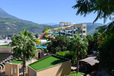 Heyecan verici slaytlar ve palmiyelerle dolu, nefes kesici dağ manzaralarıyla çevrili bir su parkı..