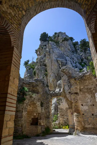 St. Hilarion Kalesi 'nin taş kemerinden büyüleyici bir manzara. Dağ manzarasını ve kalenin üst kısımlarını çerçeveliyor..