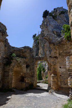 St. Hilarion Şatosu 'ndaki yıpranmış harabeler, dağların panoramik manzarasına doğru açılıyor.