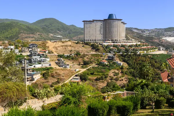 Güneşli ve sakin bir ortamda doğa ve kentsel gelişimin bir karışımını gösteren nefes kesici yamaç manzarası..