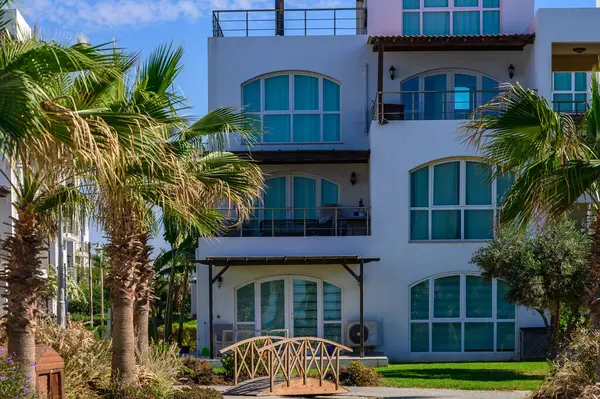 Huzurlu bir tatil köyü yapısının etrafı palmiye ağaçlarıyla çevrili. Huzurlu yeşil bir alana uzanan tuhaf bir köprü var..