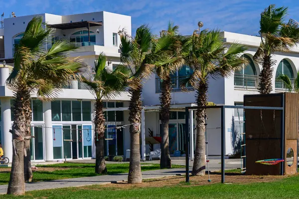 Bereketli palmiye ağaçları, geniş tesisleri ve güneşli bir günde canlı bir atmosferi olan güzel bir sahil beldesi..