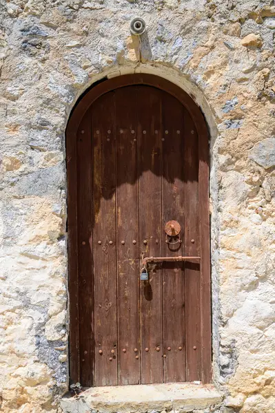 Kuzey Kıbrıs 'taki bir ortaçağ kalesi olan St. Hilarion Kalesi' nin antik ahşap kapılarına yakın çekim. Aşınmış kapılar ve yıpranmış dokuları uzun tarihi ve mimariyi gözler önüne seriyor.