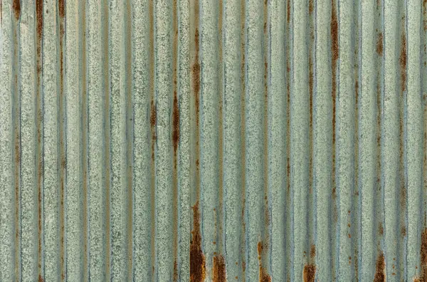 Dikey metal paneller güneş ışığına karşı bir doku ve renk karışımı sergiler, aşınma ve yıpranma tarihini ortaya çıkarır.