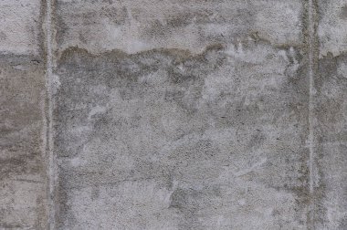 Yaşlanan beton bir duvarın yüzeyi, zamanın ve giysinin hikayesini anlatan kumaş ve gölgelerin bir karışımını sergiler..