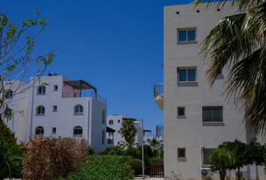 Kıbrıs 'ta deniz kenarında sakin bir komplekste parlak beyaz Akdeniz tarzı villalar.