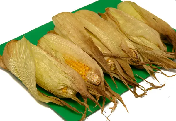 Beyaz arka planda sıralanmış mısır koçanı. Sağlıklı, kırsal ya da meze. Doğal ışıklandırma, asgari gıda tasarımı. Yemek blogları ve stok fotoğrafçılığı için ideal..