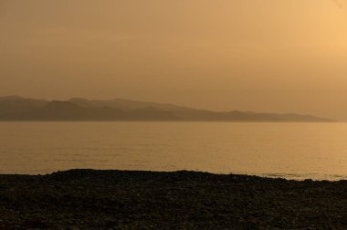 Kıbrıs kıyılarındaki sakin Akdeniz 'in üzerinde altın gün batımı.