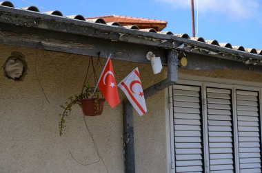 Kıbrıs Rum Kesimi ve Türkiye 'nin ulusal bayrakları Kıbrıs Rum Kesimi' nin bir köyünün duvarında yan yana sergileniyordu. Kimlik ve bölgesel gurur sembolü.
