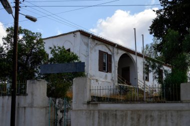 Parlak gökyüzünün altındaki huzurlu Lefke caddesinde eski evleri ve kemerli kapıları olan geleneksel Kıbrıs mimarisi.