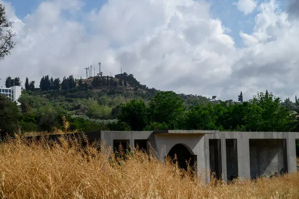 Tamamlanmamış bir konut, Kuzey Kıbrıs 'ta görülen sembol olan ikonik Atatürk siluetinin yer aldığı dağlık bir arkaplan karşısında duruyor..