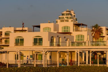 Kıbrıs 'taki beyaz bir villa kompleksinin huzurlu manzarası ılık gün batımı ışığında yıkandı,