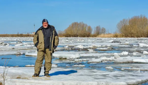 Bakhthiyar Nehri 'nde buz üstünde duran balıkçı.
