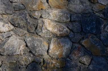 Doku arka planı olarak vahşi taş duvar yüzeyine yakın çekim. Grafik tasarımı, modelleme, mimari, inşaat ve yaratıcı arkaplan için mükemmel.