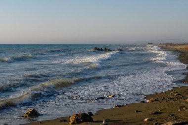 Kıbrıs 'ın Morphou Körfezi' ndeki güzel kumlu plaj, sakin Akdeniz suları ve berrak yaz gökyüzü, dinlenmeyi ve tatil atmosferini sembolize ediyor..