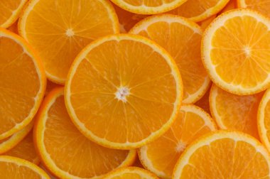 Parlak portakallar yuvarlak şeklinde dilimlenmiş ve yüzeyde yiyecek olarak sıralanmış..