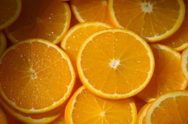 Taze portakallar dilimlenmiş ve masaya dizilmiş. Mutfak, aşçılık ve gıda tasarımı için parlak turunçgiller.