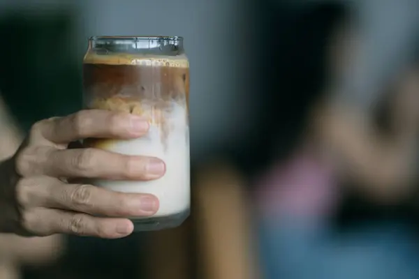 Fotokopi alanı kavramında bir bardak buzlu latte tutan bir kadın..