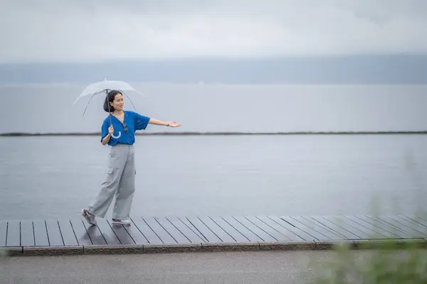 Şemsiyeli bir kadın, Yunnan, Dali 'deki Erhai Gölü. Manzara konsepti olan insanlar.
