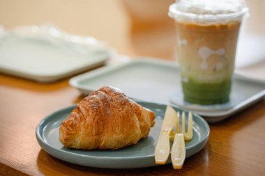 Kahve dükkanının ahşap masasında kruvasan var..