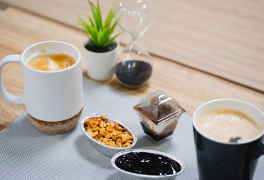 Tahta bir masada bir fincan kahve ve tatlı.