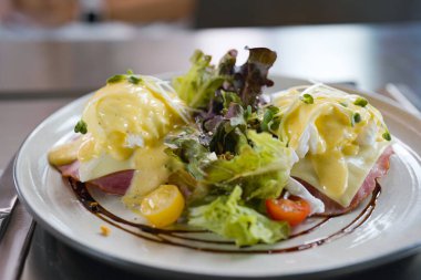 Lezzetli yumurtalı Benedict sandviçi, haşlanmış yumurta, masada jambon. 