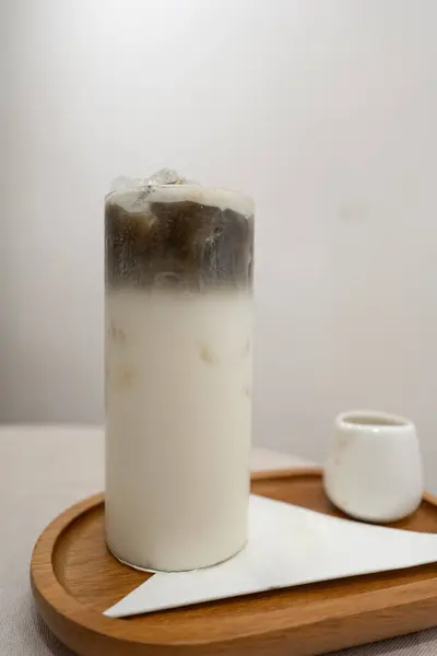 Beyaz masadaki ahşap tepside sütlü kavrulmuş yeşil çay.