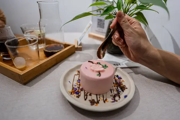 Kafede bir fincan sade kahveyle çiçek pastası yiyen bir kadının görüntüsü düz konseptte..