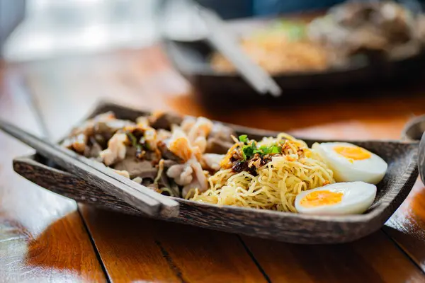 Nodles restoranında lezzetli erişteler ve ahşap tabakta domuz eti..