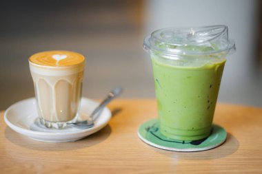Bir bardak buzlu kibrit yeşil çay, bir kahvecinin ahşap masasında buzlu latte yaz terasında.