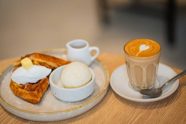 Kahve ve tatlı, pasta, waffle ve dondurma tahta masanın üstünde, seçilmiş odak.