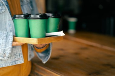 Yakın plan. Elinde kahve bardağıyla gezen bir bayan.. 