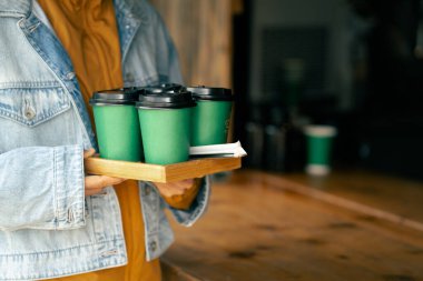 Yakın plan. Elinde kahve bardağıyla gezen bir bayan.. 