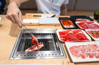 Bir kadın mutfakta et hazırlıyor. 