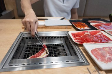 Bir kadın mutfakta et hazırlıyor. 