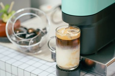 Kahve fincanı ve kahve makinesi masanın üstünde.